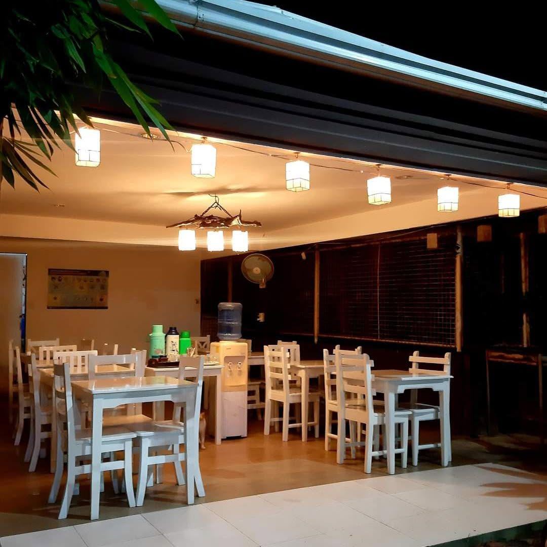 Open dining area with white tables and hanging lights
