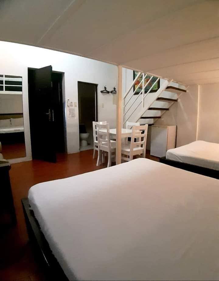 Loft room with two beds, a dining table and stairs