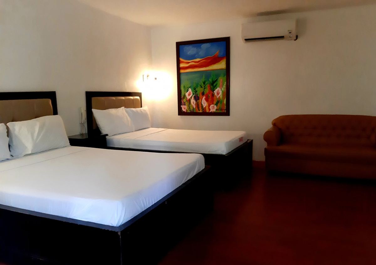 Room with two beds, a sofa and air conditioning